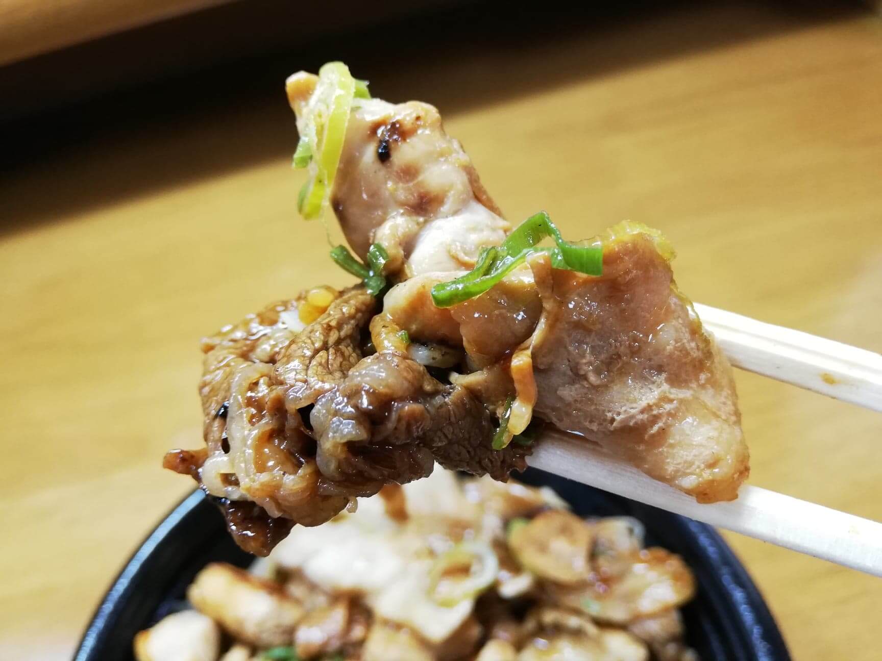 吉野家の『スタミナ超特盛丼』の肉を箸で掴んでいる写真