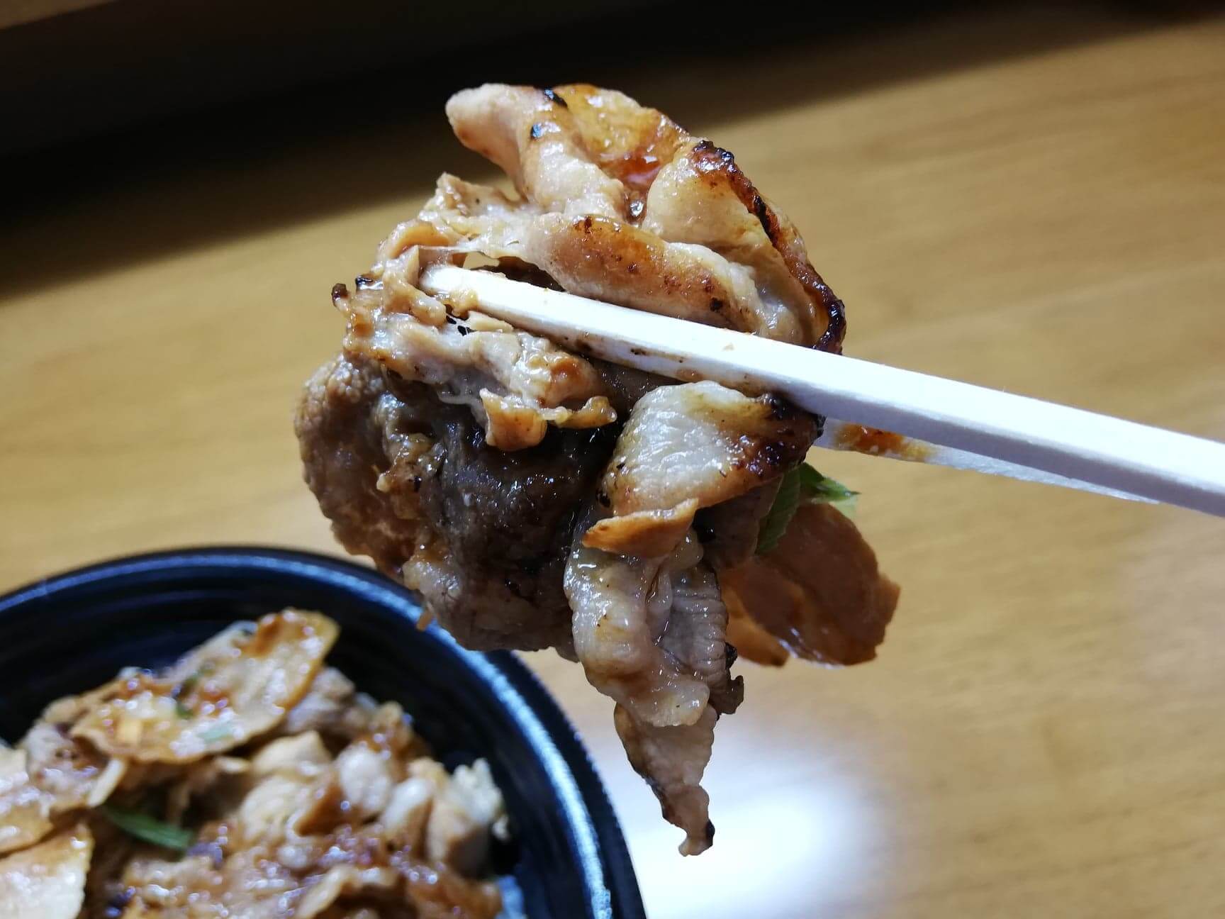 吉野家の『スタミナ超特盛丼』の肉を箸で掴んでいる写真